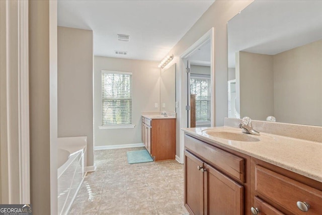 145 Sunset Ln, Woodstock, GA 30189 - bathroom featuring a bath, two vanities, baseboards, and tile patterned flooring
