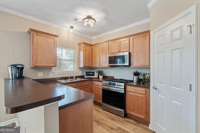 145 Sunset Ln, Woodstock, GA 30189 - kitchen featuring stainless steel appliances, a peninsula, a sink, dark countertops, and crown molding