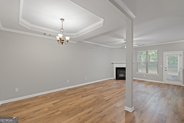 145 Sunset Ln, Woodstock, GA 30189 - unfurnished living room with a chandelier, light wood finished floors, a ceiling fan, a raised ceiling, and a fireplace with flush hearth