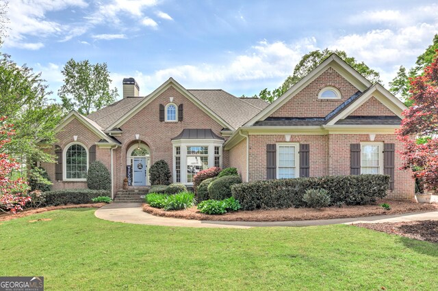 8155 Legends View Ct, Cumming, GA 30028 - colonial house with brick siding, a chimney, a front lawn, and a shingled roof