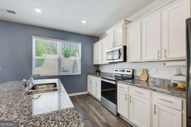 221 Sullivan St, Hampton, GA 30228 - kitchen with white cabinetry, a sink, appliances with stainless steel finishes, and dark wood finished floors