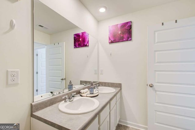 221 Sullivan St, Hampton, GA 30228 - bathroom with baseboards, visible vents, a sink, and double vanity