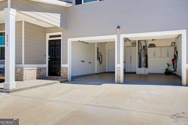 221 Sullivan St, Hampton, GA 30228 - doorway to property with stone siding, water heater, and driveway