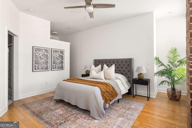 bedroom with light wood-style flooring, baseboards, and ceiling fan