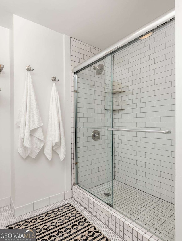 full bathroom with tile patterned flooring, baseboards, and a shower stall