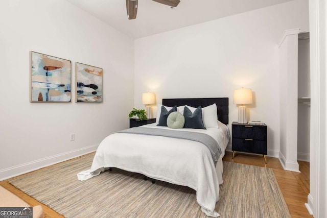 bedroom with baseboards, ceiling fan, and wood finished floors