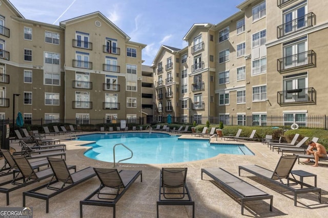 pool with fence and a patio area