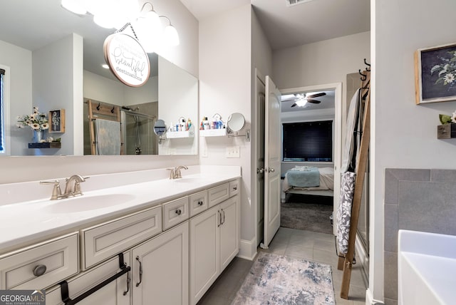 full bathroom featuring a shower stall, a sink, double vanity, ensuite bath, and tile patterned flooring
