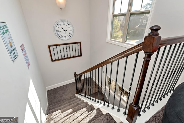 staircase featuring carpet and baseboards