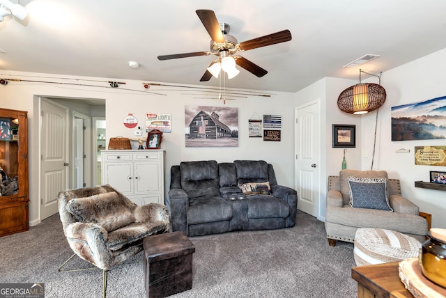 living room with visible vents, ceiling fan, and carpet flooring