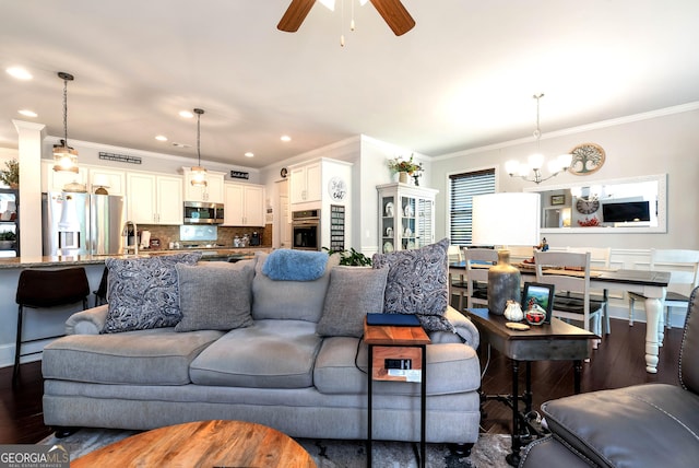 living area featuring ornamental molding, recessed lighting, ceiling fan with notable chandelier, and dark wood finished floors