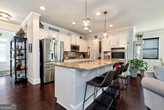 kitchen with light stone countertops, a healthy amount of sunlight, appliances with stainless steel finishes, and a sink