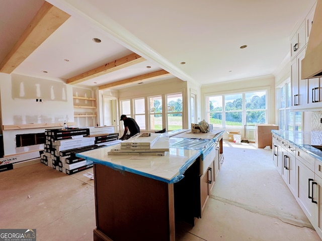 699 Rambler Inn Rd, Jefferson, GA 30549 - kitchen with light stone counters, a kitchen island, white cabinetry, ventilation hood, and beam ceiling