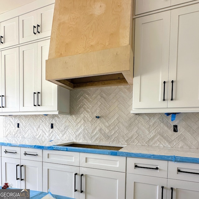 699 Rambler Inn Rd, Jefferson, GA 30549 - kitchen with custom range hood, backsplash, black electric cooktop, white cabinets, and light countertops