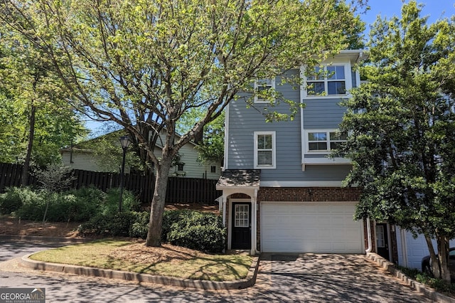 234 Carlyle Park Dr NE, Atlanta, GA 30307 - view of front of house with fence, concrete driveway, a garage, and brick siding