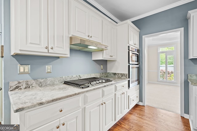 kitchen with white cabinets, stainless steel appliances, under cabinet range hood, and light wood-style floors