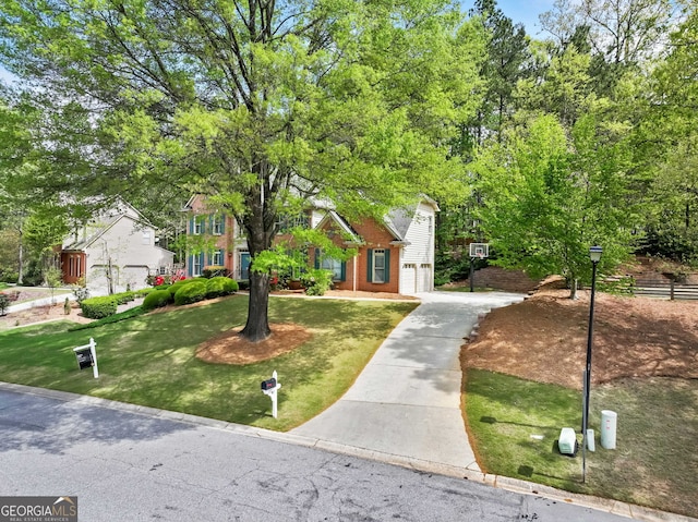 view of front of property featuring a front lawn, driveway, brick siding, and a garage