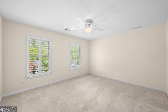 spare room with light carpet, baseboards, and visible vents