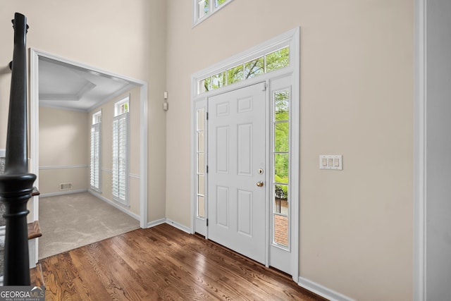 entryway featuring wood finished floors, visible vents, baseboards, and a healthy amount of sunlight