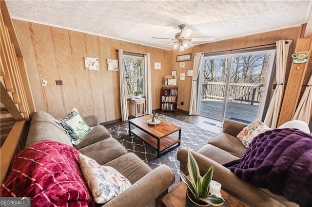 1006 Chestnut Cove Trl, Jasper, GA 30143 - living room with a textured ceiling, wooden walls, a ceiling fan, and baseboards