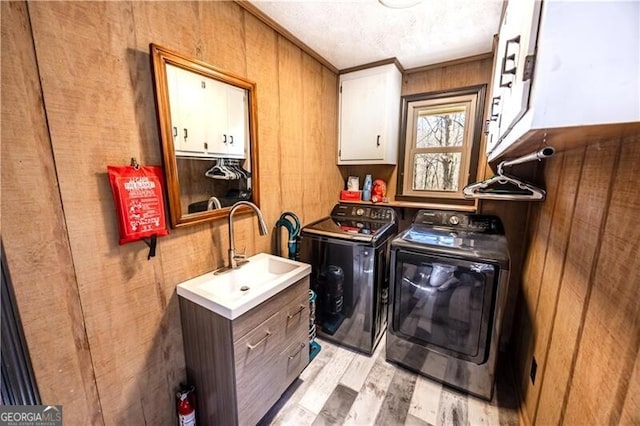 1006 Chestnut Cove Trl, Jasper, GA 30143 - laundry room with cabinet space, washing machine and clothes dryer, light wood-type flooring, wood walls, and ornamental molding