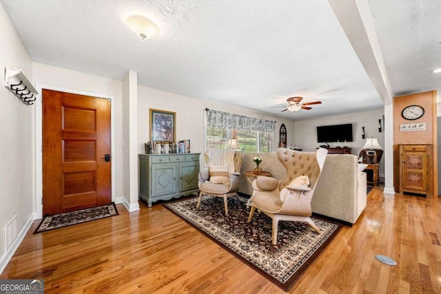 1505 Robinhood Trl, Gainesville, GA 30501 - living room with light wood-style floors, a ceiling fan, and a textured ceiling