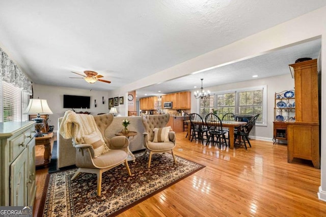 1505 Robinhood Trl, Gainesville, GA 30501 - living room with light wood-type flooring, ceiling fan, and a chandelier