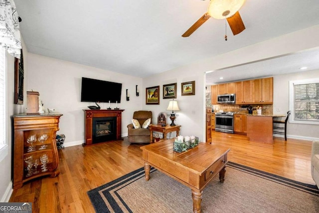 1505 Robinhood Trl, Gainesville, GA 30501 - living room featuring light wood-style floors, a glass covered fireplace, and a ceiling fan