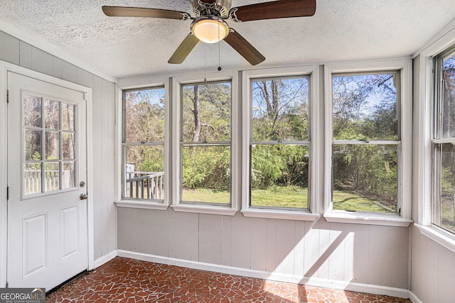 910 Brandon Hill Way, Jonesboro, GA 30238 - unfurnished sunroom featuring plenty of natural light, baseboards, a textured ceiling, and wood walls