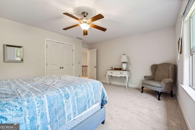 bedroom featuring light carpet, baseboards, a closet, and a ceiling fan