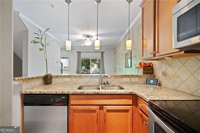 kitchen with a sink, appliances with stainless steel finishes, light stone counters, and crown molding