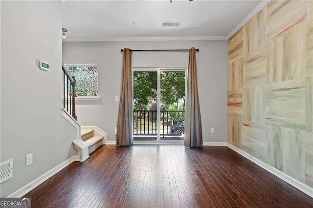 unfurnished room with stairs, crown molding, baseboards, visible vents, and hardwood / wood-style floors