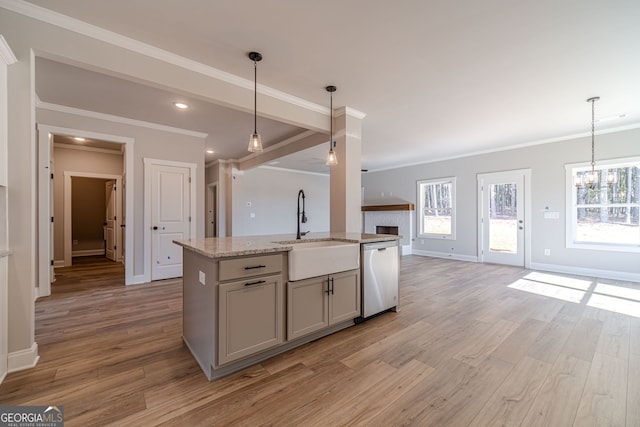 kitchen featuring dishwasher, a sink, open floor plan, ornamental molding, and light wood-type flooring