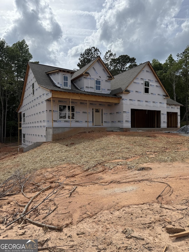 unfinished property featuring a porch and a garage