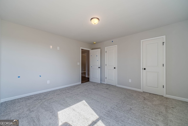 unfurnished bedroom with carpet flooring and baseboards