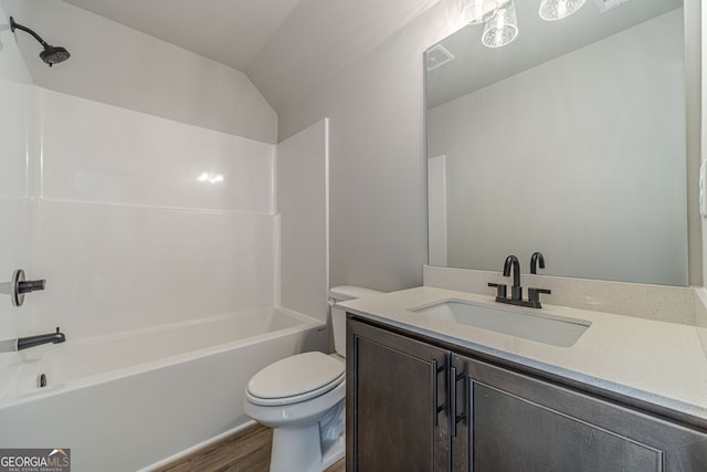 full bath with toilet, wood finished floors,  shower combination, vanity, and vaulted ceiling