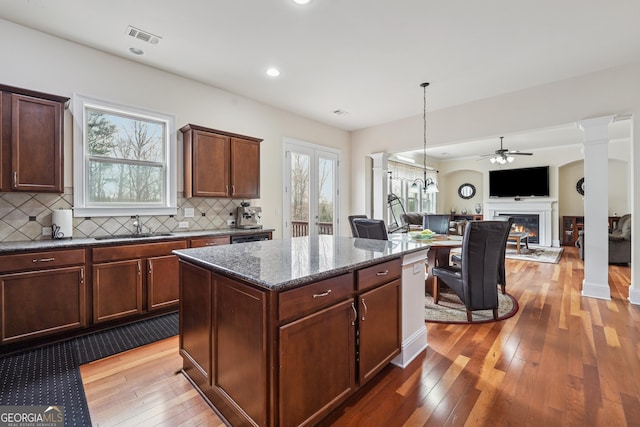 2220 Stirling Bridge Rd, Cumming, GA 30041 - kitchen with wood-type flooring, a sink, visible vents, a ceiling fan, and a glass covered fireplace