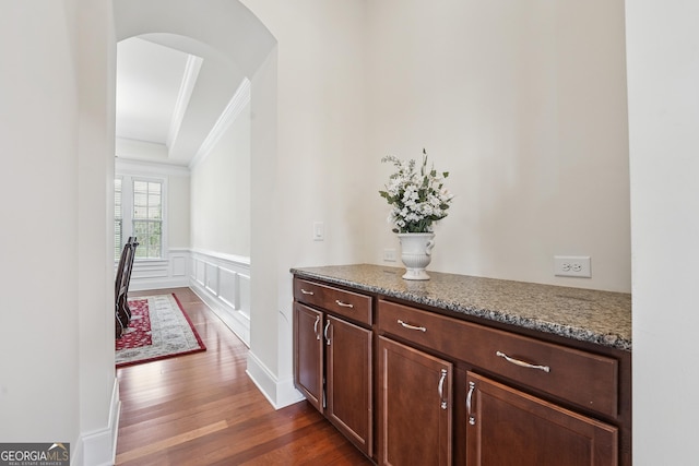 2220 Stirling Bridge Rd, Cumming, GA 30041 - corridor with a wainscoted wall, a decorative wall, arched walkways, ornamental molding, and dark wood-style flooring