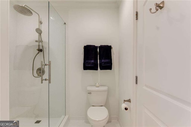 full bathroom with a stall shower, baseboards, and toilet