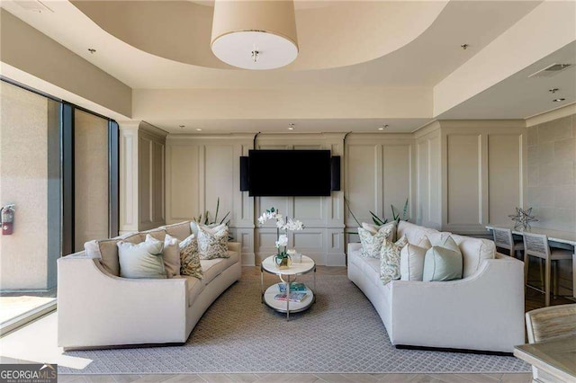 living room featuring a decorative wall and visible vents