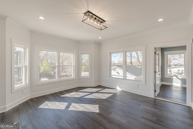 unfurnished dining area with dark wood-type flooring, ornamental molding, and baseboards