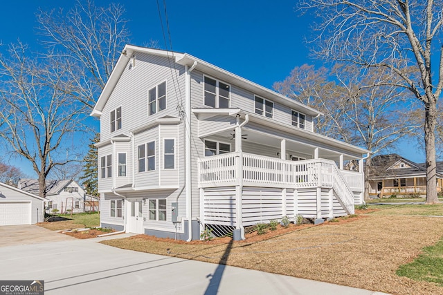 view of front of property featuring covered porch, ceiling fan, a front yard, and an outbuilding