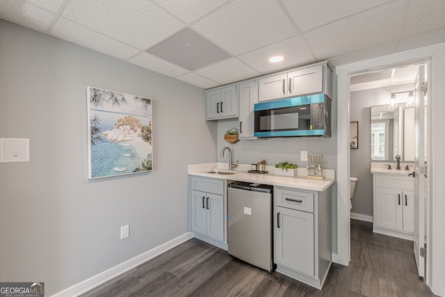 kitchen featuring baseboards, light countertops, a sink, and stainless steel dishwasher