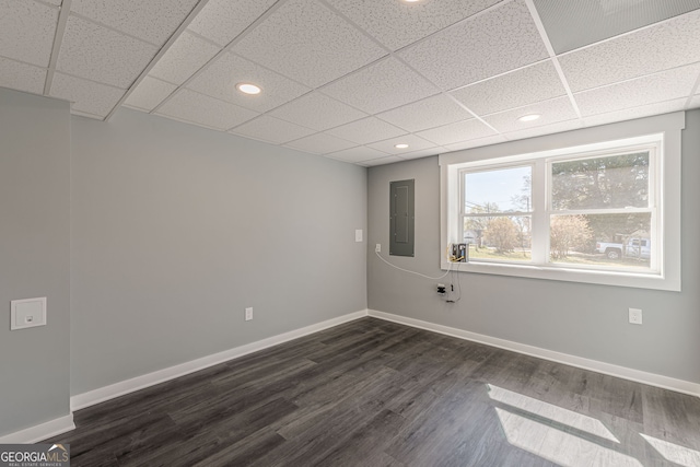 unfurnished room featuring electric panel, baseboards, recessed lighting, dark wood-style floors, and a paneled ceiling