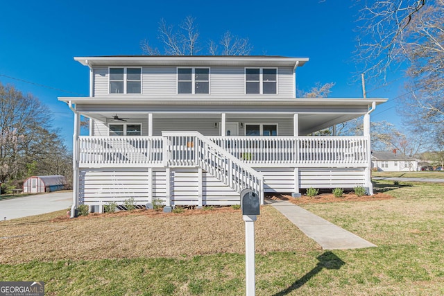 view of front of property with a front lawn, covered porch, and ceiling fan
