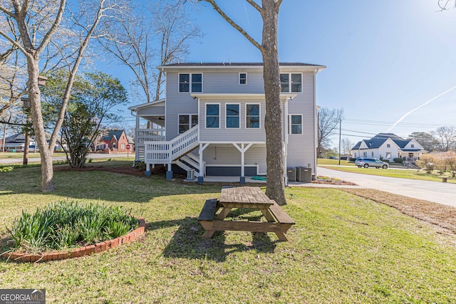 back of property featuring a lawn and central AC