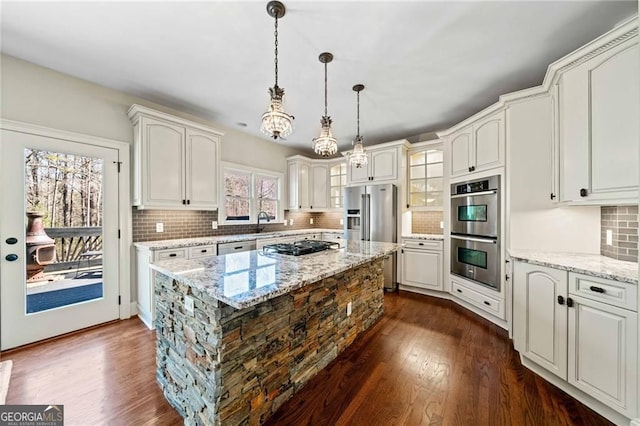 3795 Duckcove Way, Cumming, GA 30041 - kitchen featuring appliances with stainless steel finishes, dark wood finished floors, decorative backsplash, and pendant lighting
