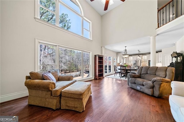 3795 Duckcove Way, Cumming, GA 30041 - living room with a towering ceiling, a ceiling fan, dark wood-style floors, decorative columns, and baseboards