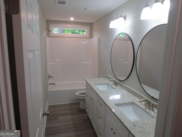505 Palomino Ln, Warner Robins, GA 31088 - bathroom with wood finished floors, toilet, double vanity, tub / shower combination, and recessed lighting