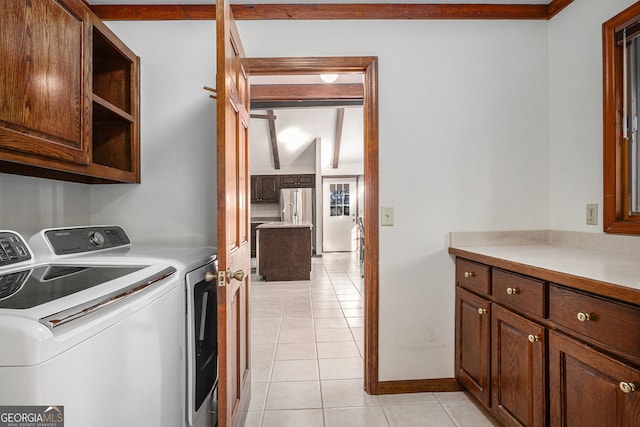 laundry room with light tile patterned floors, washer and clothes dryer, cabinet space, and baseboards